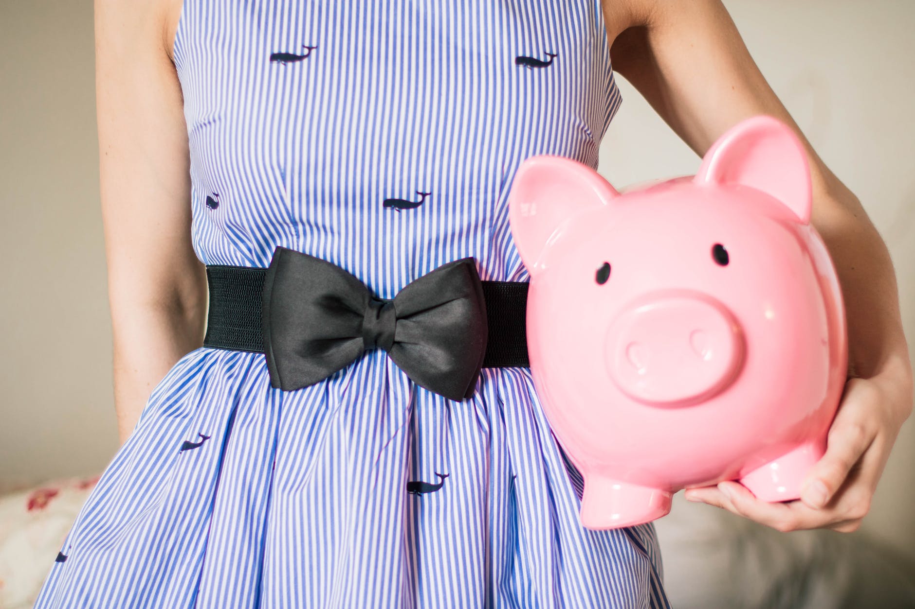 lady in stripped dress with piggy bank
